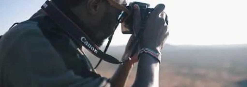 A photographer shooting with a Canon camera above a valley